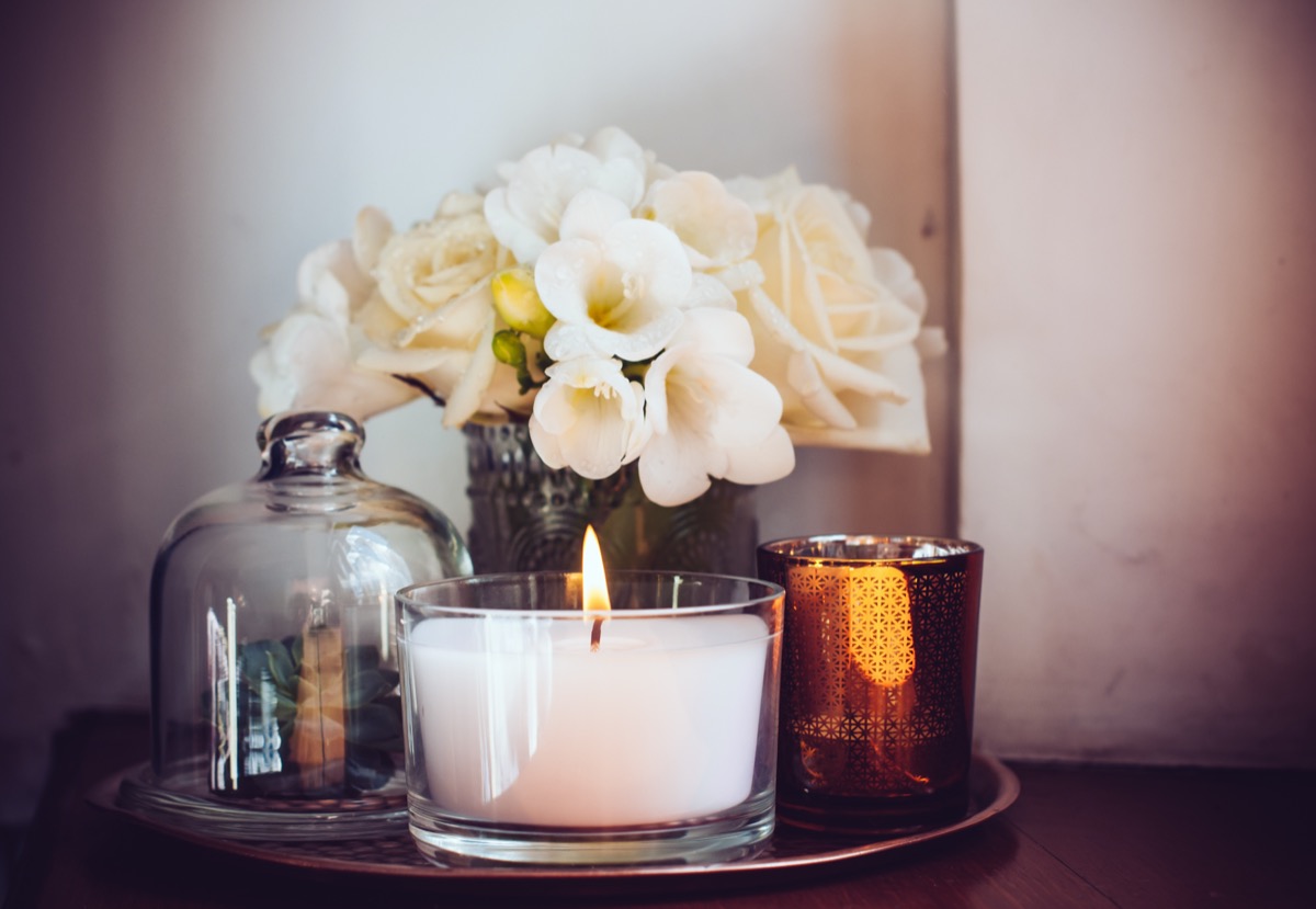 white candle in glass jar on tray