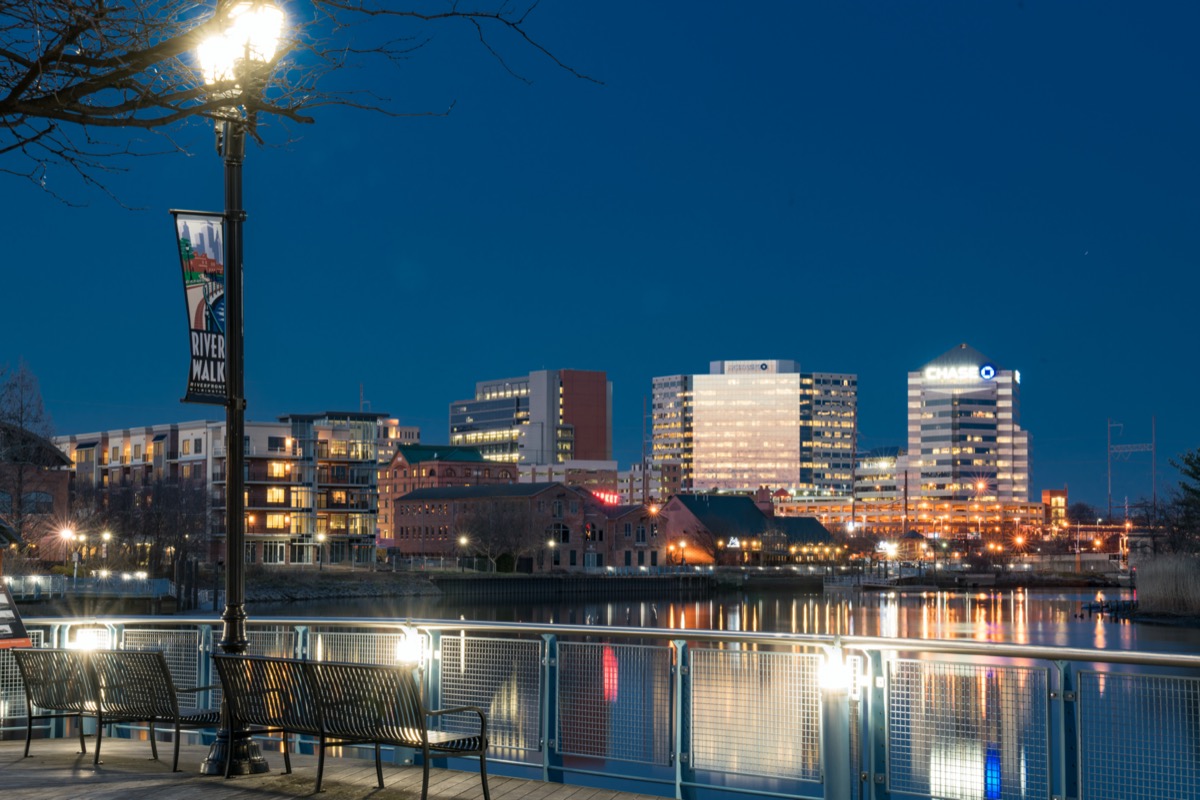 cityscape photo of a pier, lake, and buildings at River Walk Park in Wilmington, Delaware at night