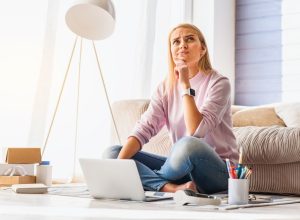 woman looking upset at computer in modern home