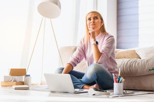 woman looking upset at computer in modern home
