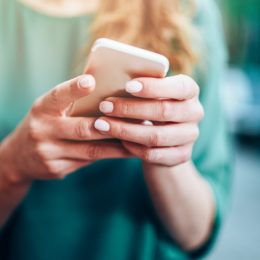 Close-up of an unrecognizable woman using smart phone