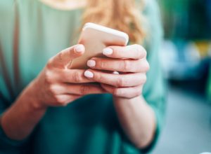 Close-up of an unrecognizable woman using smart phone