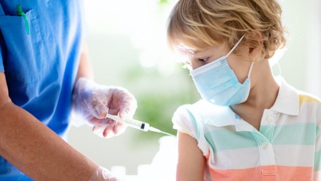 young white boy wearing mask getting vaccine