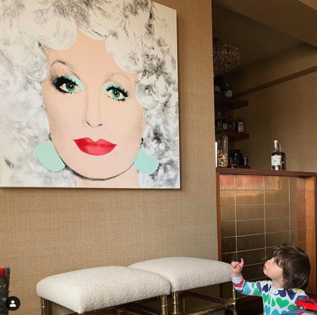 Andy Cohen's son looking at Dolly Parton painting