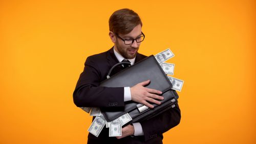 Greedy man holding a suitcase full of money