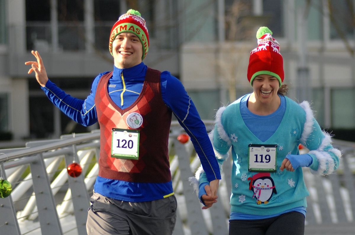 Young man and woman in Ugly Christmas Sweater race