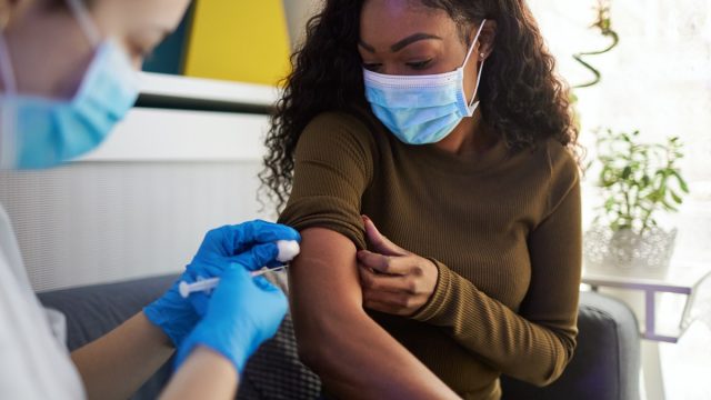 woman gets vaccinated at home during pandemic times.
