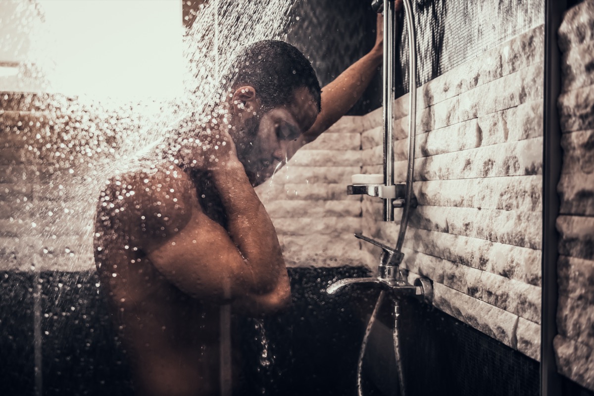 ผู้ชายกำลังอาบน้ำในห้องน้ำตอนเช้า  ชายยืนถือลำตัวเปล่าในห้องน้ำ  กิจวัตรยามเช้าส่วนตัว  สดชื่นยามเช้า