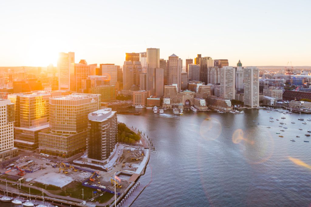 An aerial photo of the skyline of Boston, Massachusetts, taken at sunset from the water.