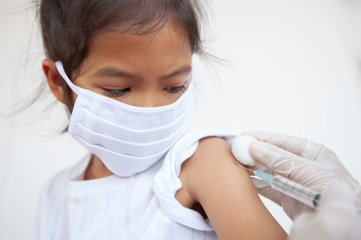 Doctor injecting vaccination on child in arm