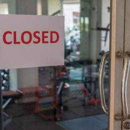 Closed sign on a glass of the door in gym due to Covid-19