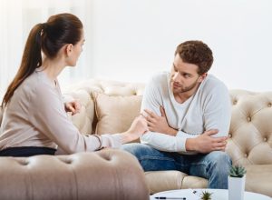 man looking at woman and woman towards to the man on a couch