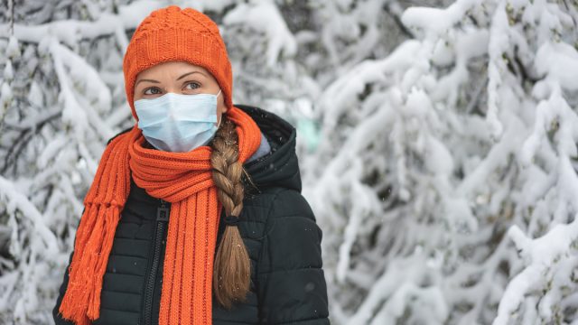 Woman in winter clothes wearing mask outdoors