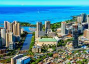 An aerial view of downtown Honolulu, Hawaii, with Waikiki beach in the background.