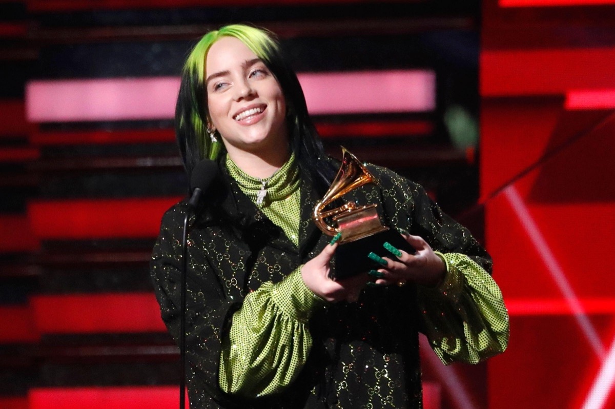 Billie Eilish holding up her Grammy at the awards show in 2020
