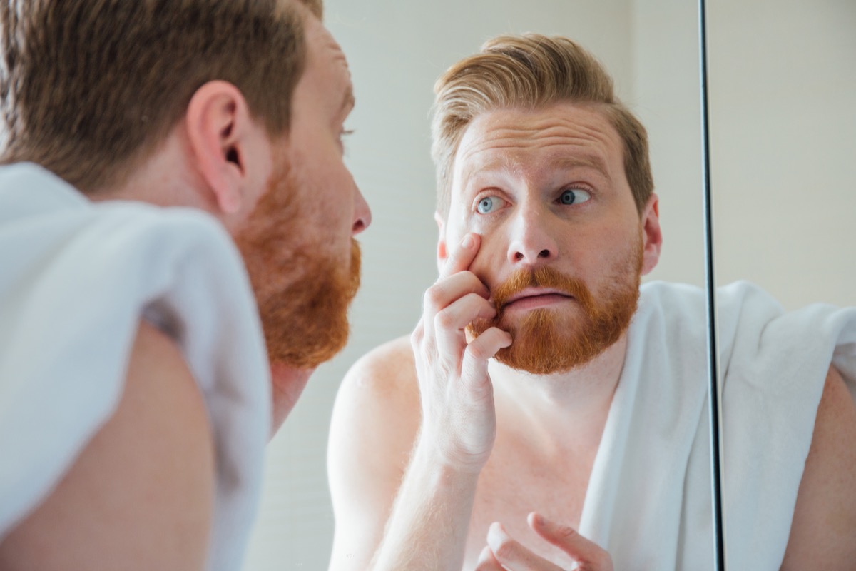 Млад мъж прави домашен очен преглед в банята