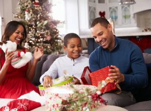 man opening presents with family
