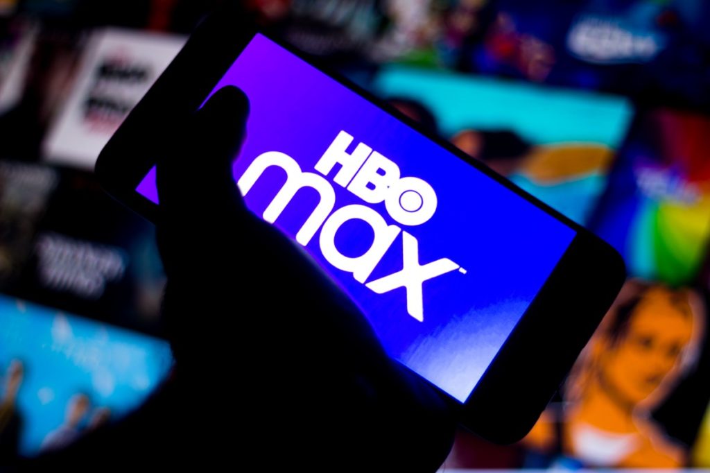 a phone in someone's hand that says HBO Max on the screen