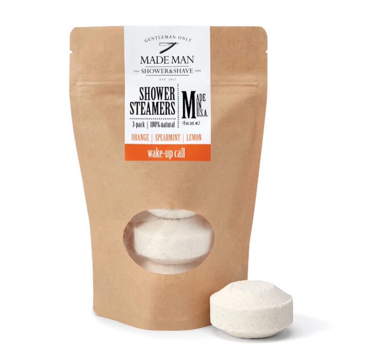 brown paper bag reading "shower steamers" with a small puck-like white object next to it