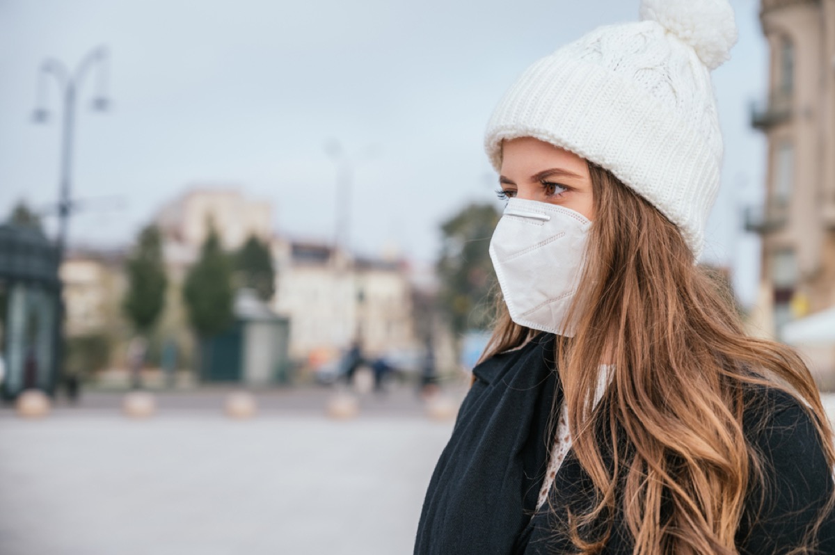 woman wearing a face mask and winter clothes outside