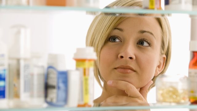 woman looking at her medicine cabinet