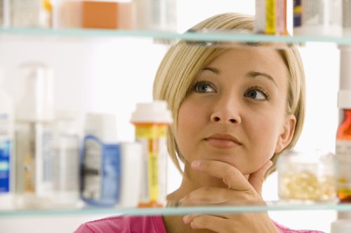 woman looking at her medicine cabinet