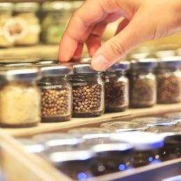 closeup woman's hand picking jar of spices