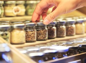 closeup woman's hand picking jar of spices