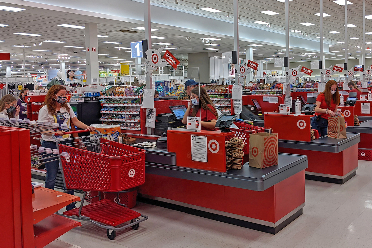 Target customers in checkout line wearing masks, separated from cashier by clear glass panel in Danvers Massachusetts in September 19, 2020