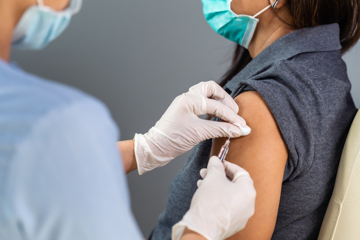 Woman getting vaccine first