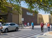 Kennesaw, GA / USA - 04/05/20: Walmart line outside the store with masked people practicing social distancing 6 feet apart during Covid-19 Corona Virus Pandemic.