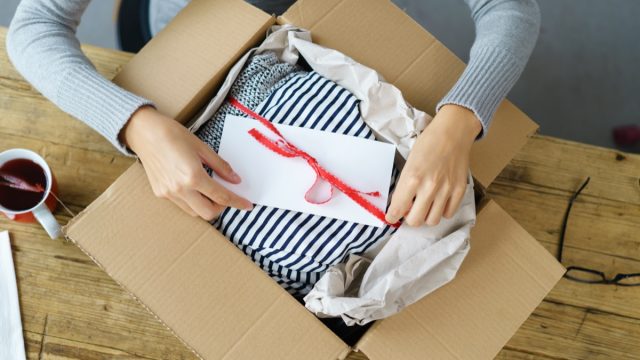 woman opening gift in cardboard box