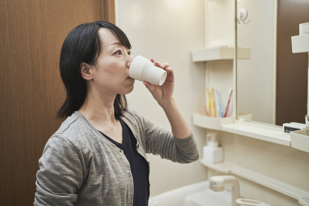 Woman gargling with oral rinse in the washroom