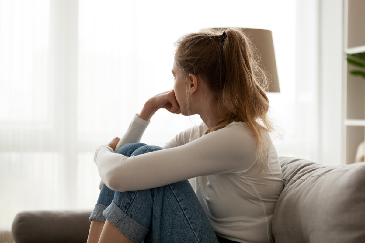 Woman sitting on couch in deep thought