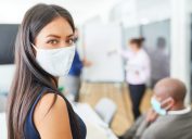 young woman wearing covid mask in office