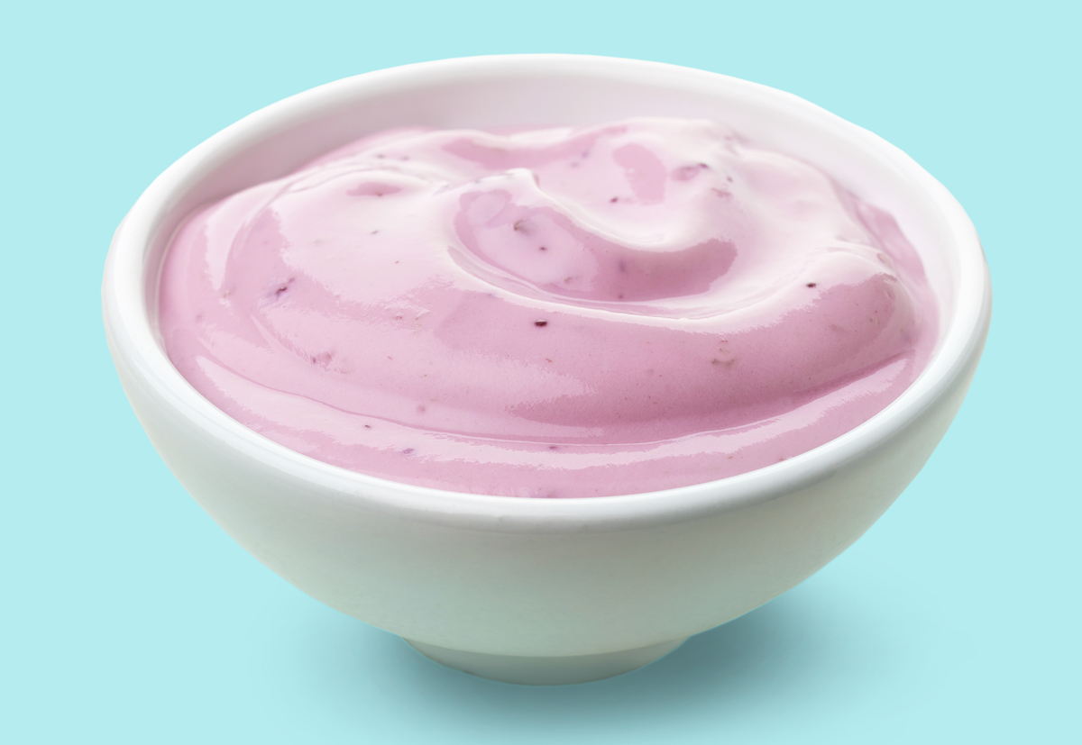 bowl of blueberry fruit yogurt on blue background