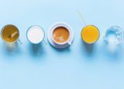 Tea, Milk, Coffee, Orange Juice, and Water on Table with Top View on Blue Background