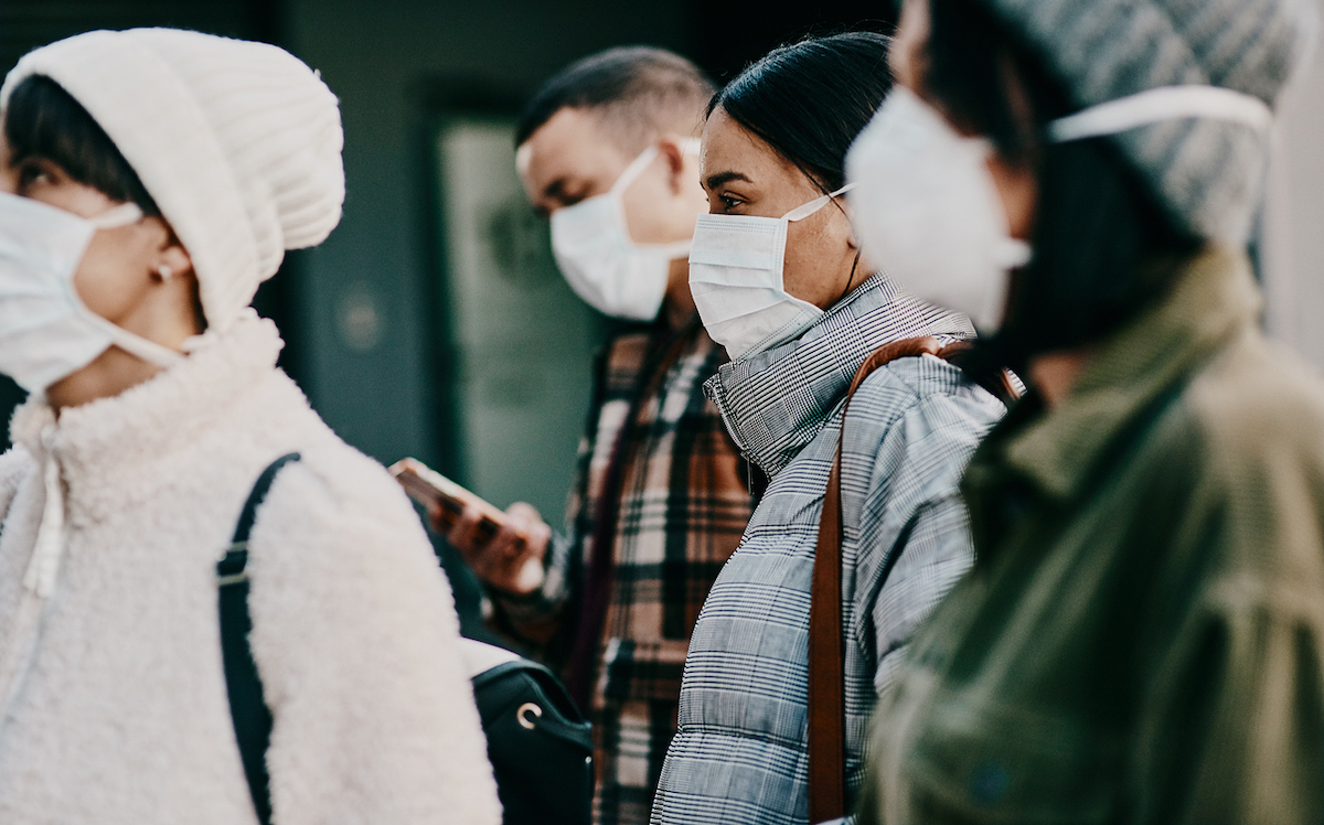 Shot of a group of young people wearing masks on the street in the cold weather