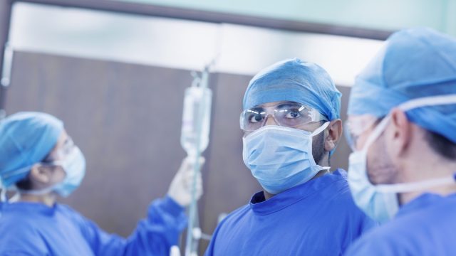 Doctor looking up at monitor in operating room