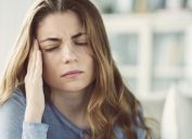 Young woman with headache in home interior