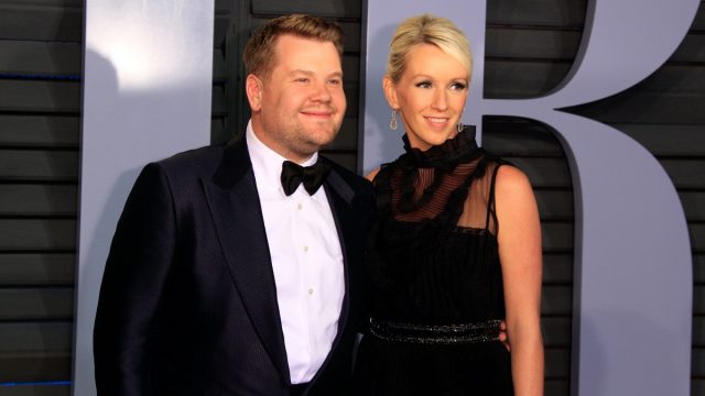 james corden and his wife julia carey on the red carpet in a black suit and dress, respectively