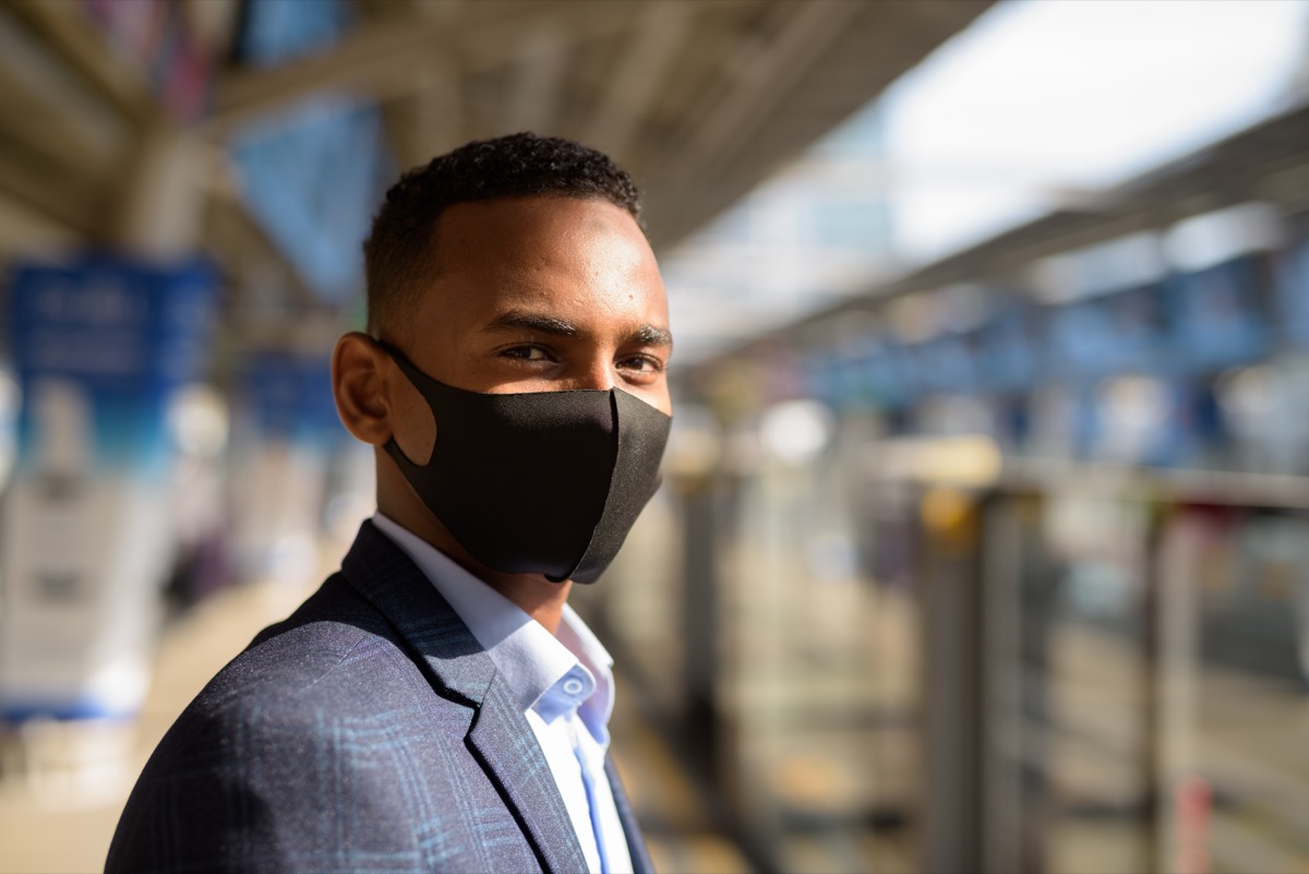 Portrait of young man with mask for protection from corona virus outbreak at the sky train station