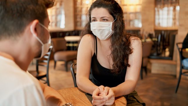 woman and man at restaurant wearing masks