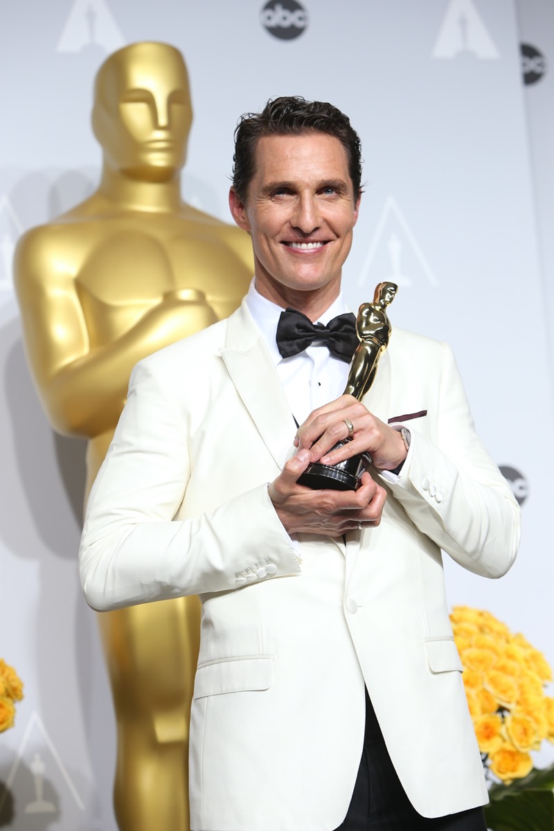 matthew mcconaughey in a white suit holding an oscar