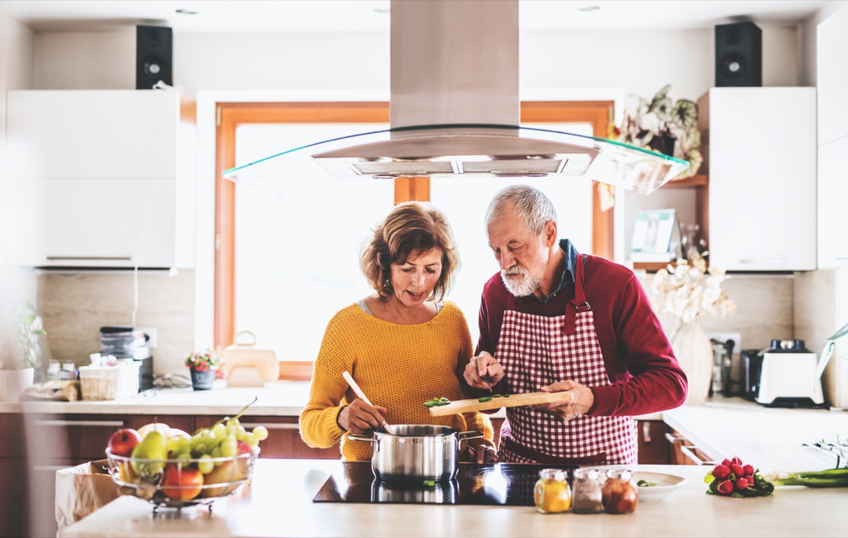 Cuplu în vârstă pregătește mâncarea împreună