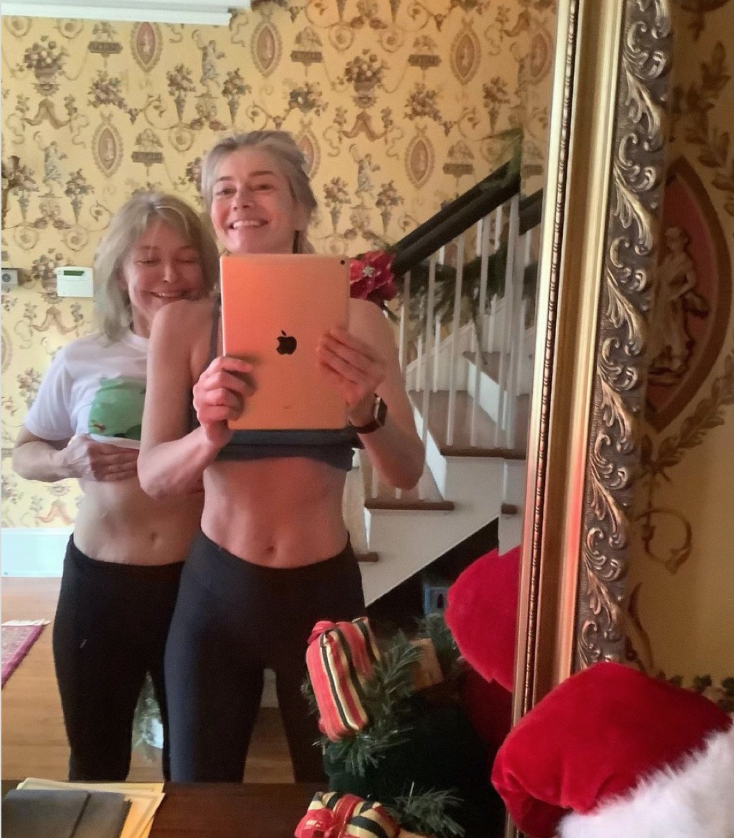 paulina porizkova and her mother showing their stomachs while taking a photo with an ipad in a mirror in a home