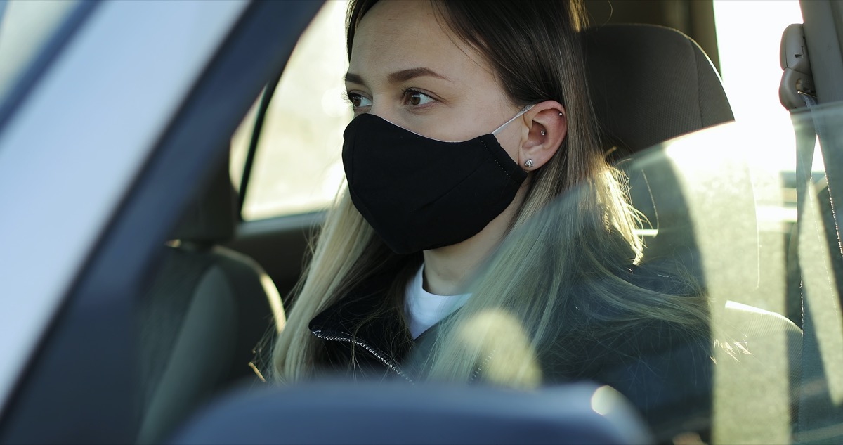 blonde woman wearing mask in car