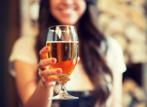 young woman holding a glass of beer