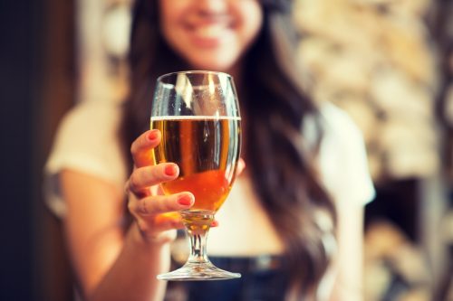 young woman holding a glass of beer