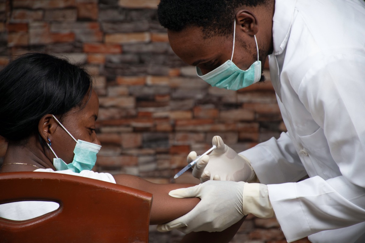 young male doctor giving young female patient covid vaccine